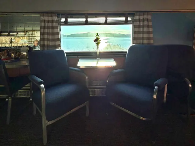 Lounge chairs in shadow, the Hudson River and hills bright in the window